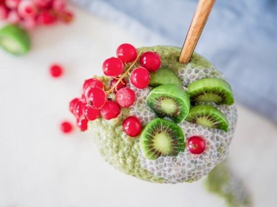 green matcha and chia pudding with baby kiwis and cranberries