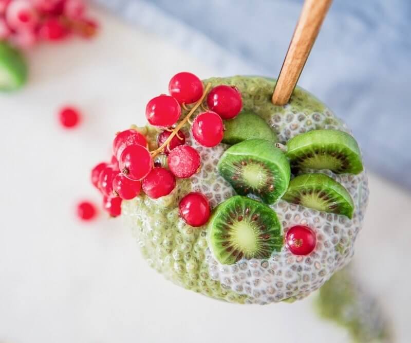 green matcha and chia pudding with baby kiwis and cranberries