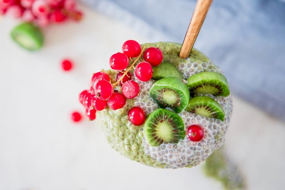 green matcha and chia pudding with baby kiwis and cranberries